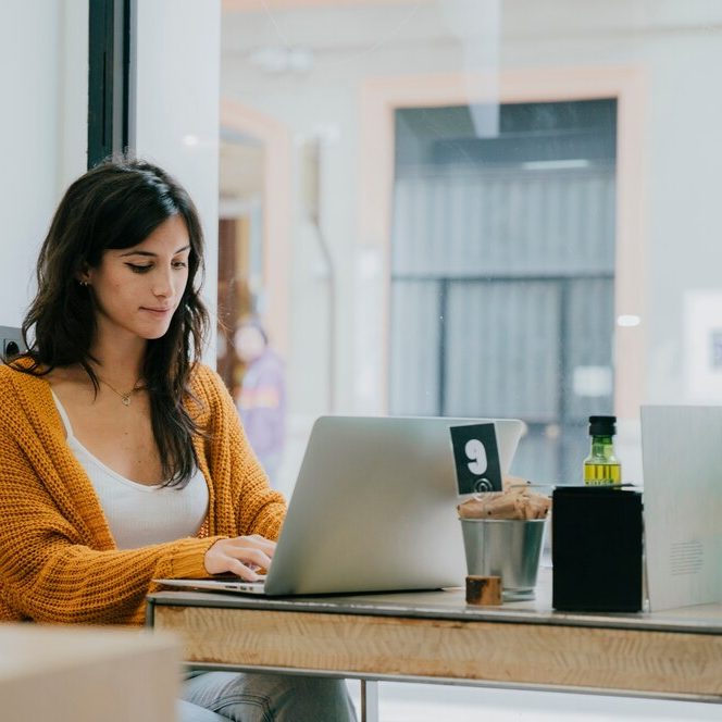 lovely-woman-browsing-laptop-cafe